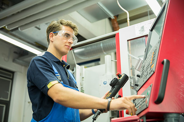 Robert Kramer an einer computergesteuerten Fräsmaschine in der Werkstatt.