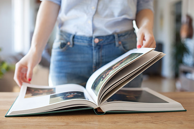 Frau blättert durch ein Fotobuch.