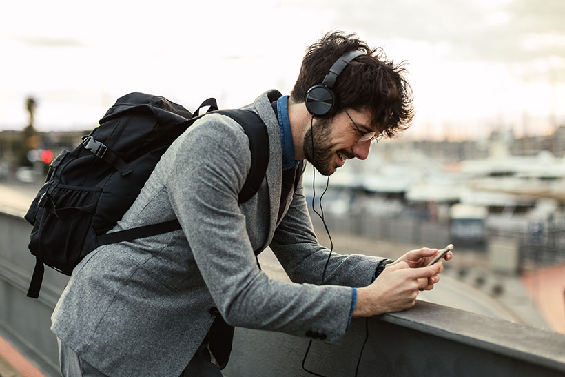 Mann mit Kopfhörern und Smartphone in der Hand