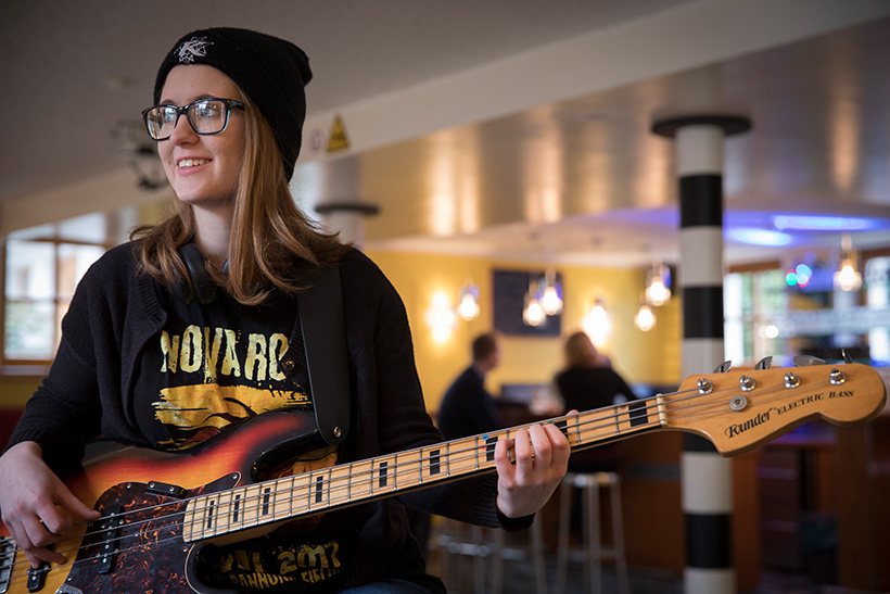 Junge Frau mit einer E-Gitarre