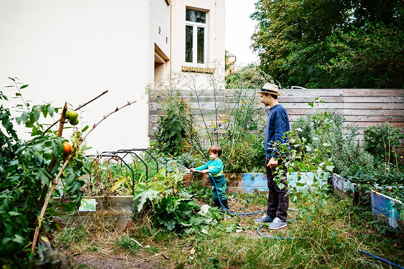 Vater und Sohn im Ökogarten hinter ihrem Haus
