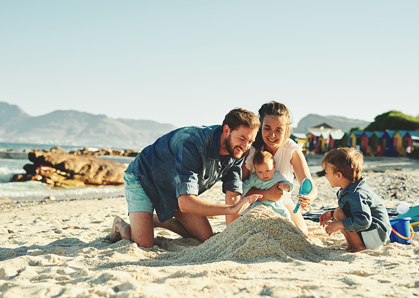 Familie baut Sandburg am Strand