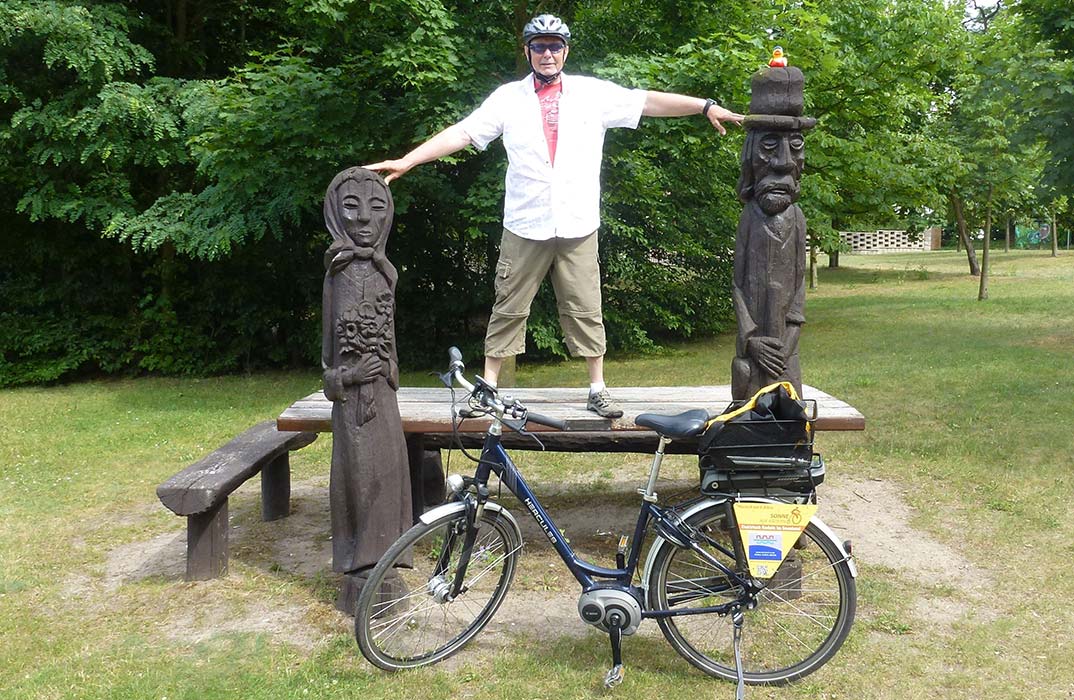 Mann auf einer Bank mit E-Bike davor
