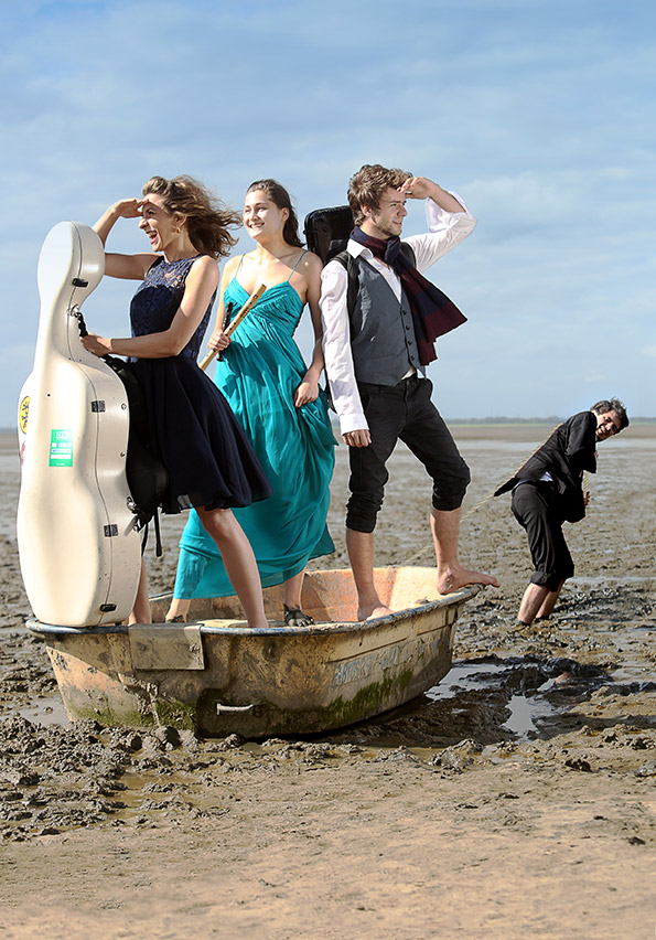 Drei Musiker in einem Boot am Strand