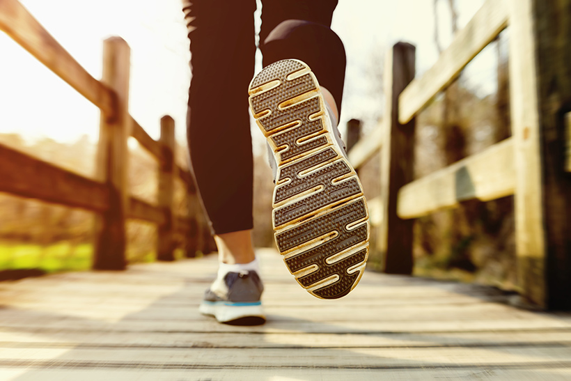 Beine eines Joggers von hinten mit Blick auf die Laufschuhe