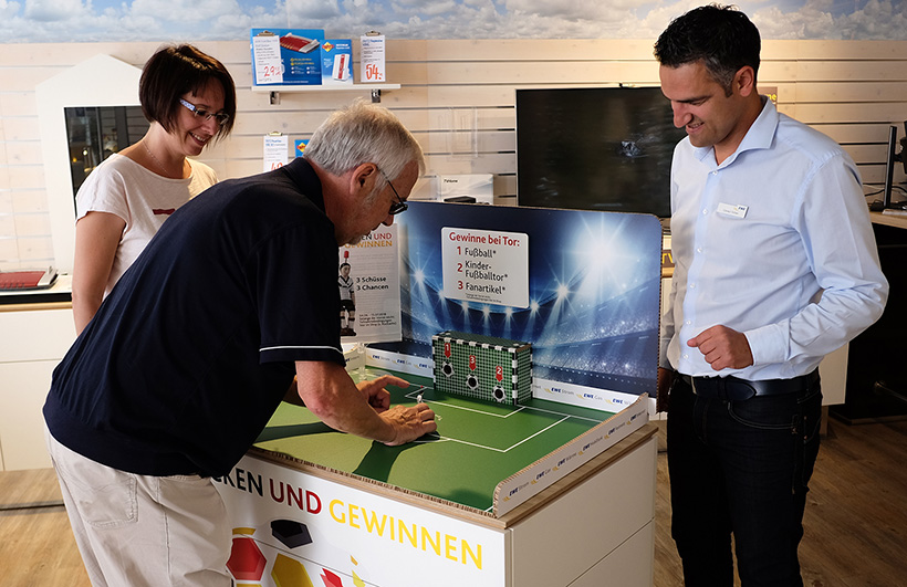 Andrea und Heiner Rieger und Cüneyt Gülten beim Tipp-Kicken im EWE ServicePunkt Delmenhorst