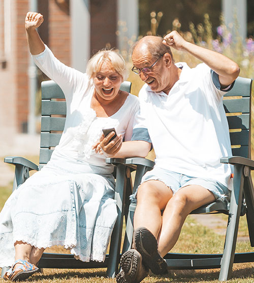 Ein Ehepaar schaut gemeinsam aufs Smartphone.